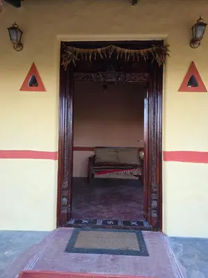 a mirror in a room with a bed in it at Namma Hatti, Traditional Home in Chattanahalli