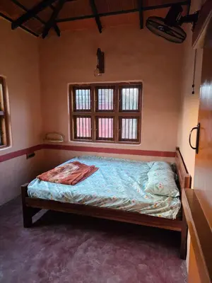 a bed in a room with a window at Namma Hatti, Traditional Home in Chattanahalli