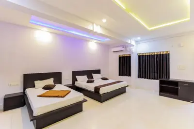 a bedroom with two beds and a television in it at Igloo Residency in Vythiri