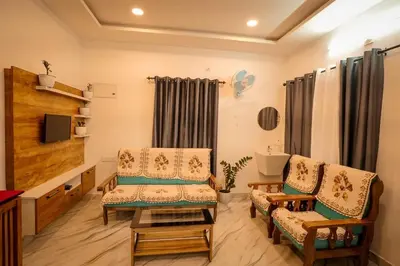 a living room with two chairs and a television at Cozy Nest Villa in Mananthavady