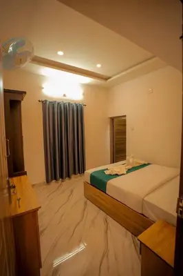 a hotel room with a bed and a window at Cozy Nest Villa in Mananthavady