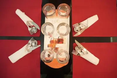 a table with two glasses and forks and napkins at Cozy Nest Villa in Mananthavady