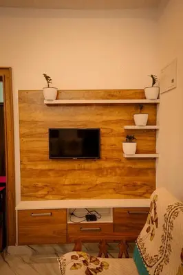 a tv on a wooden wall with potted plants at Cozy Nest Villa in Mananthavady