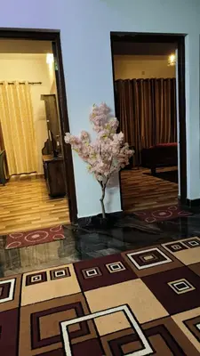 a room with a vase of flowers on the floor at Tea Garden stays in Ooty