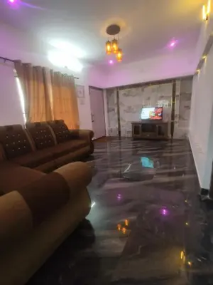 a living room with a couch and a television at Tea Garden stays in Ooty