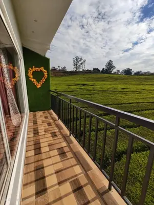 a balcony with a heart on a green field at Tea Garden stays in Ooty