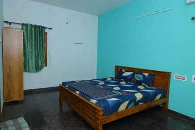 a bedroom with a bed in a blue room at 2Bhk White House Near Isha By Shivalaya Stays in Coimbatore