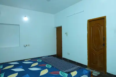 a room with a blue wall and a door at 2Bhk White House Near Isha By Shivalaya Stays in Coimbatore