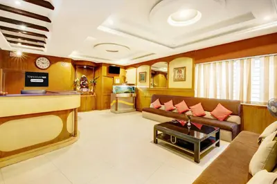 a living room with a couch and a table at Super Townhouse Oak Mysuru City Bus Terminal in Mysore