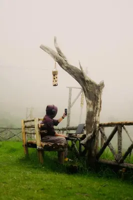 a person sitting on a bench taking a picture at Elim Retreat kanthalloor in Kanthalloor