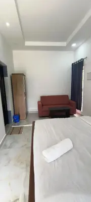 a bedroom with a white bed and a couch at Blue home stay in Kanthalloor