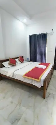 a bedroom with a large bed with red pillows at Blue home stay in Kanthalloor