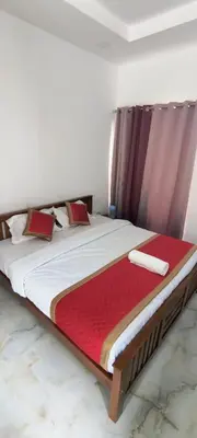 a bedroom with a large bed with a red blanket at Blue home stay in Kanthalloor