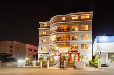 a tall white building at night with lights at Treebo Akshaya Palace Inn in Mysore