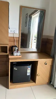a cabinet with a mirror and a television in it at Sonam hotel and restaurant in Kushālnagar