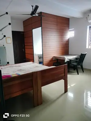 a bedroom with a bed and a table and chairs at Aswathy Bhavan Vadakkenchery Near Star auditorium in Vadakkāncheri