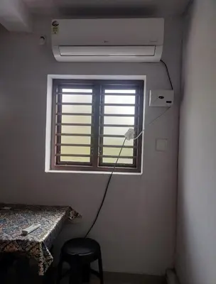 a room with a ceiling fan and a window at Aswathy Bhavan Vadakkenchery Near Star auditorium in Vadakkāncheri