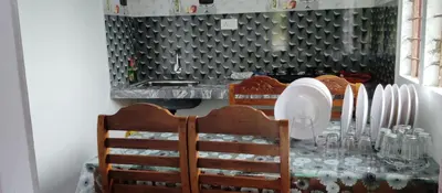 a dining room table with chairs and plates on it at Misty plaza in Munnar