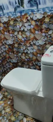 a white toilet sitting in front of a wall of mushrooms at Misty plaza in Munnar
