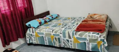 a bedroom with a bed with a comforter on it at Misty plaza in Munnar