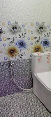 a bathroom with a toilet with flowers on the wall at Misty plaza in Munnar