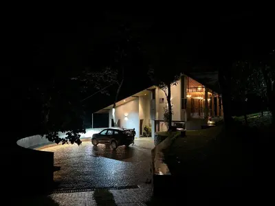 a car parked in front of a house at night at Lucas Rainforest in Kakkabe