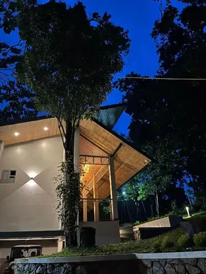 a house with a tree in front of it at night at Lucas Rainforest in Kakkabe