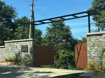 a gate in a stone wall with a wooden door at Lucas Rainforest in Kakkabe