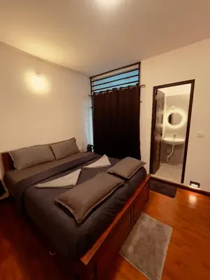 a bedroom with two beds and a large mirror at Vaj N Sat Villas in Kodaikānāl