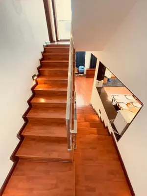 a staircase in a house with wooden floors and ceilings at Vaj N Sat Villas in Kodaikānāl
