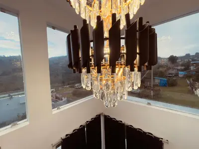 a chandelier hanging in a room with windows at Vaj N Sat Villas in Kodaikānāl