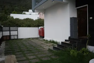 a white house with a white fence and stairs at Vaj N Sat Villas in Kodaikānāl
