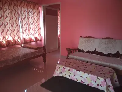 a living room with two benches and a window at Lakshmi Vasan Homestay in Madikeri