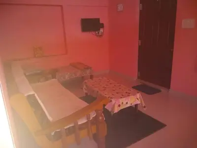 a room with a table and a table and chairs at Lakshmi Vasan Homestay in Madikeri