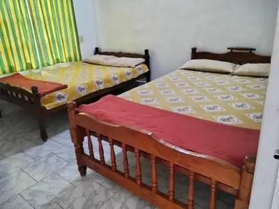 two beds sitting next to each other in a room at Lakshmi Vasan Homestay in Madikeri