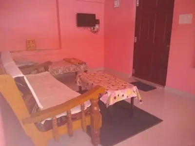 a room with two tables and a table and chairs at Lakshmi Vasan Homestay in Madikeri