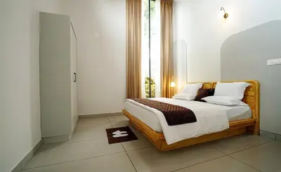 a bedroom with a bed and a window at wayanadjunglevillas in Kenichira
