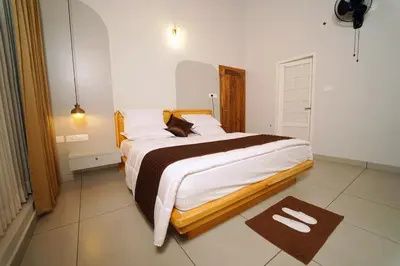 a bedroom with a large bed in a room at wayanadjunglevillas in Kenichira
