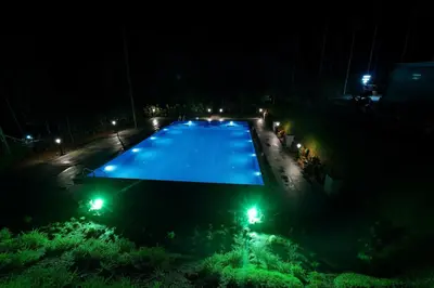 an overhead view of a swimming pool at night at wayanadjunglevillas in Kenichira