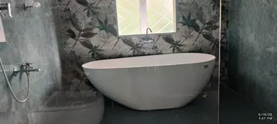 a bathroom with a tub and a window and a toilet at Tusker villa in Suntikoppa