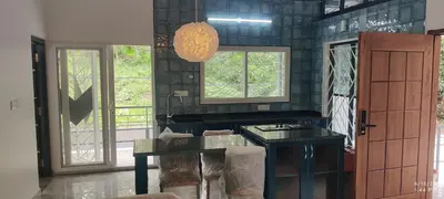 a bathroom with a counter with a sink and windows at Tusker villa in Suntikoppa