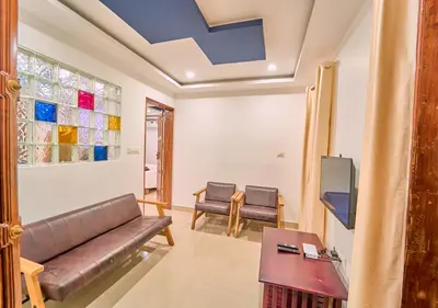 a living room with a couch and a table at Kedara Resort Wayanad by VOYE HOMES - Pet Friendly with Pool in Sultan Bathery