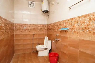 a bathroom with a toilet and a red trash can at Climate Dull - Homestay Villa in Ketti