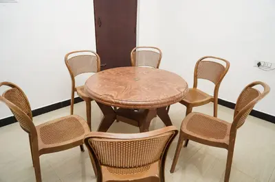 a wooden table with four chairs and a table and a table at Climate Dull - Homestay Villa in Ketti