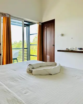 a bedroom with a white bed with a large window at Zero Degree in Ketti