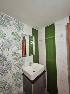 a bathroom with a sink and green and white wallpaper at Tranquil Nest Villa - Wayanad in Kalpetta
