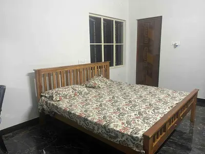 a bed sitting in a room with a window at AC 3BHK Full House Kitchen strong WiFi Pollachi in Pollāchi