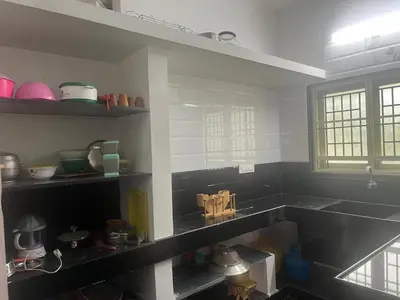 a kitchen with black counters and shelves with dishes at AC 3BHK Full House Kitchen strong WiFi Pollachi in Pollāchi