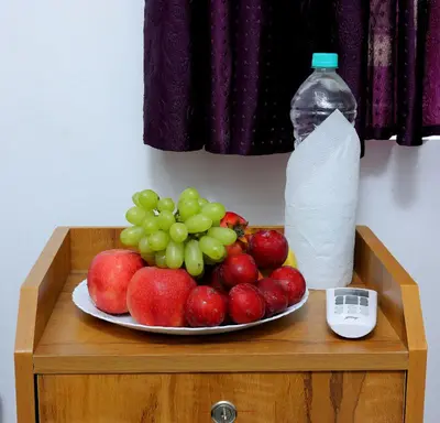 a plate of fruit on a table with a bottle of water at Ganesha Homestay, Cochin, Near Paniyeli Poru Waterfalls in Malayāttūr