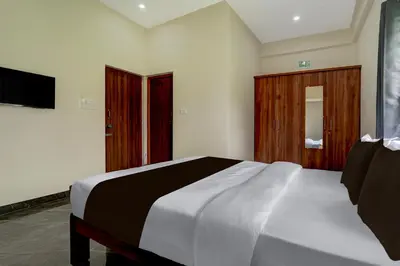 a bedroom with a large bed and a television at Hotel O Ambari Residency in Mysore